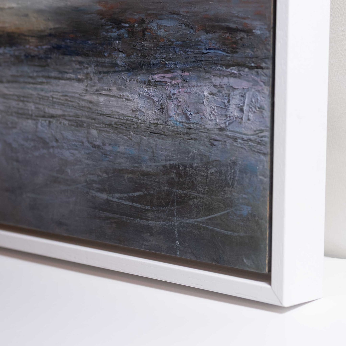 Abstract painting with a textured surface in a white frame on a light background