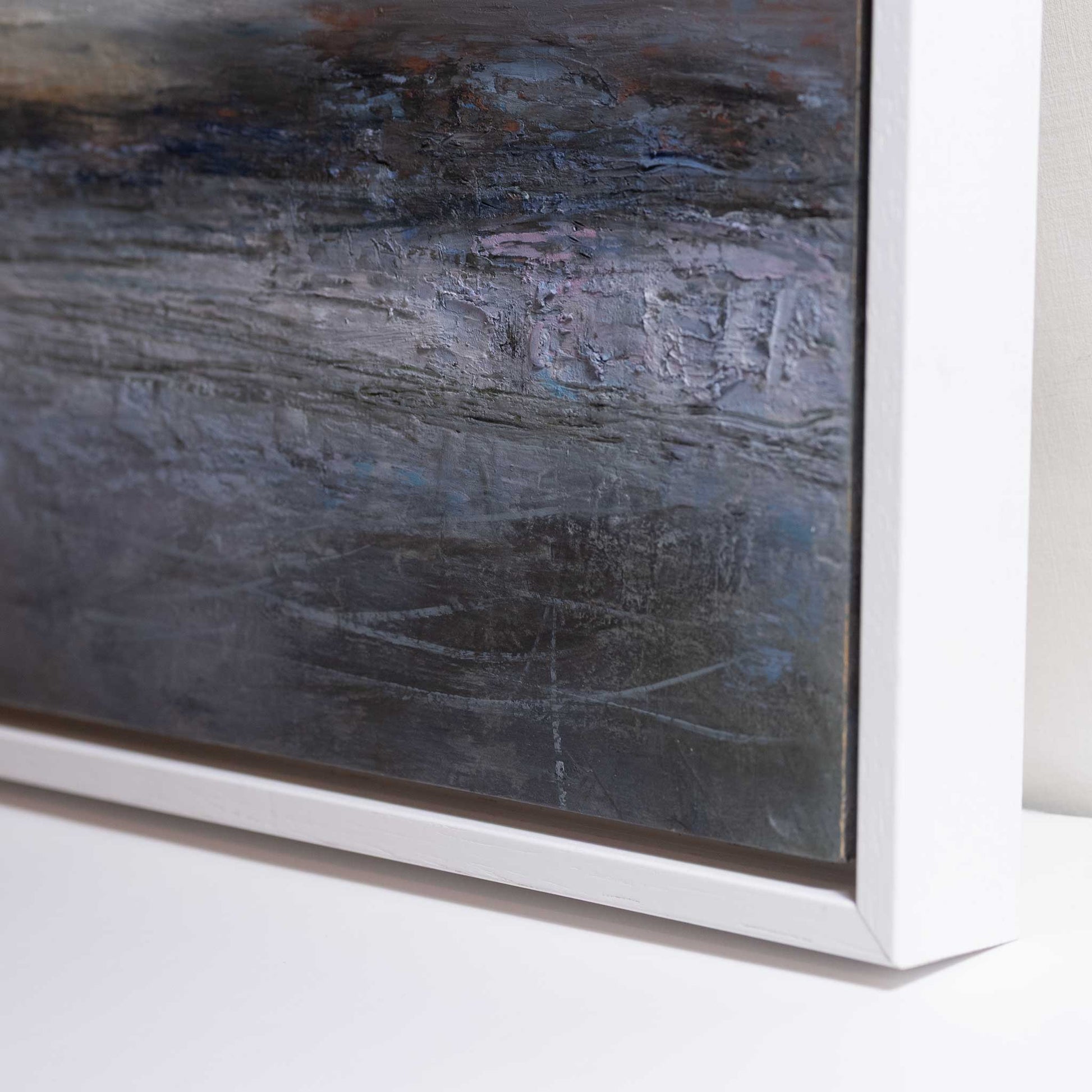 Abstract painting with a textured surface in a white frame on a light background