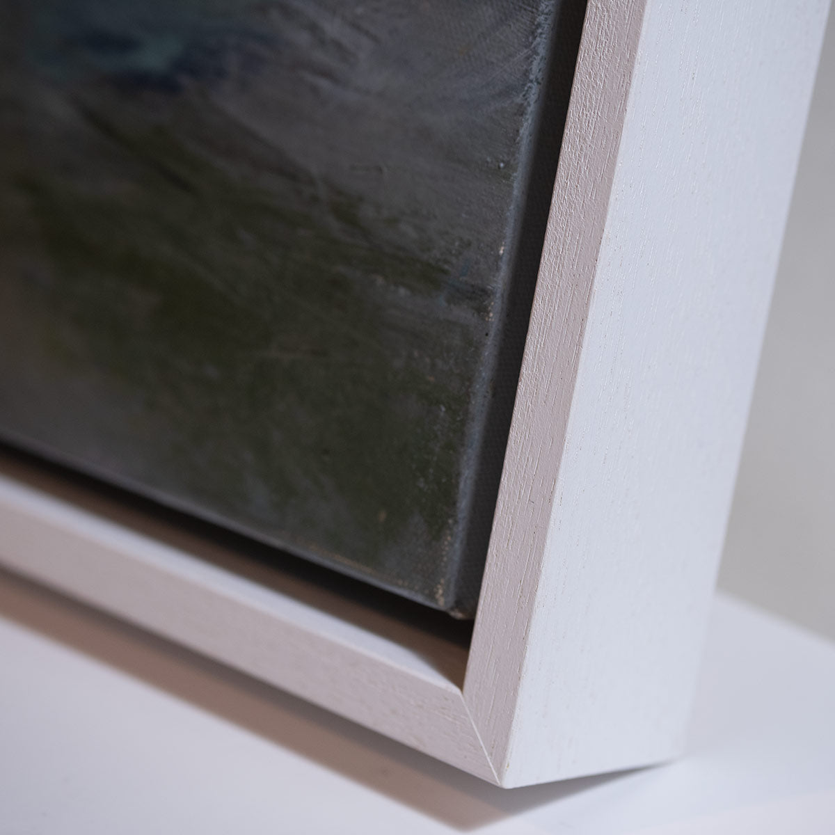 close up of right hand side of painting showing the white frame at an angle 