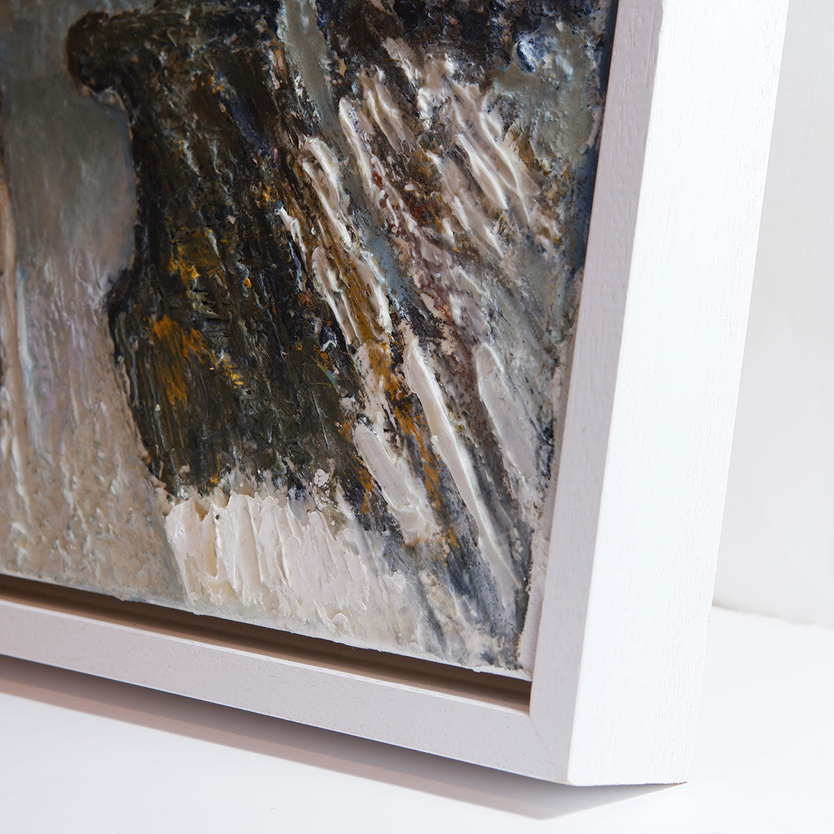 Close-up of an abstract painting with a white frame on a light background